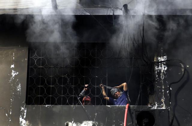 (260120) -- KARACHI, Jan. 20, 2026 (Xinhua) -- Rescuers work at the fire site at a shopping mall in southern Pakistani port city of Karachi on Jan. 20, 2026. The death toll from a massive fire at a multi-storey commercial building in Pakistan's southern port city of Karachi has risen to 26, while 74 people are still missing, officials said on Tuesday. (Str/Xinhua)