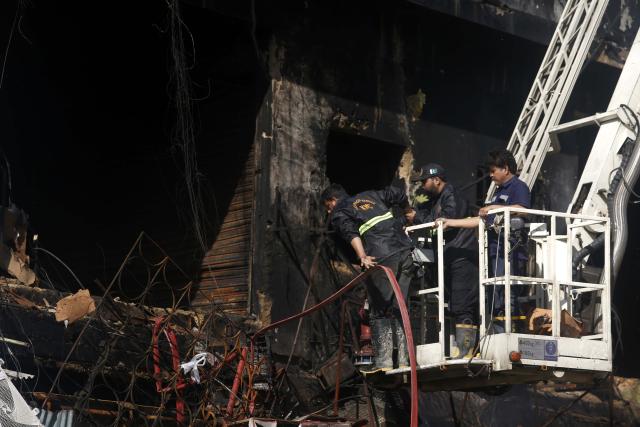 (260120) -- KARACHI, Jan. 20, 2026 (Xinhua) -- Rescuers work at the fire site at a shopping mall in southern Pakistani port city of Karachi on Jan. 20, 2026. The death toll from a massive fire at a multi-storey commercial building in Pakistan's southern port city of Karachi has risen to 26, while 74 people are still missing, officials said on Tuesday. (Str/Xinhua)