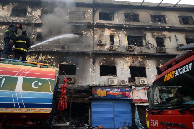 (260120) -- KARACHI, Jan. 20, 2026 (Xinhua) -- Rescuers work at the fire site at a shopping mall in southern Pakistani port city of Karachi on Jan. 20, 2026. The death toll from a massive fire at a multi-storey commercial building in Pakistan's southern port city of Karachi has risen to 26, while 74 people are still missing, officials said on Tuesday. (Str/Xinhua)