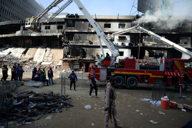 (260120) -- KARACHI, Jan. 20, 2026 (Xinhua) -- Rescuers work at the fire site at a shopping mall in southern Pakistani port city of Karachi on Jan. 20, 2026. The death toll from a massive fire at a multi-storey commercial building in Pakistan's southern port city of Karachi has risen to 26, while 74 people are still missing, officials said on Tuesday. (Str/Xinhua)
