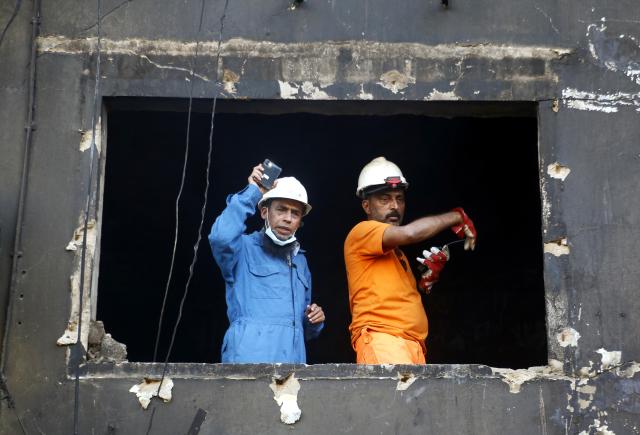 (260120) -- KARACHI, Jan. 20, 2026 (Xinhua) -- Rescuers work at the fire site at a shopping mall in southern Pakistani port city of Karachi on Jan. 20, 2026. The death toll from a massive fire at a multi-storey commercial building in Pakistan's southern port city of Karachi has risen to 26, while 74 people are still missing, officials said on Tuesday. (Str/Xinhua)