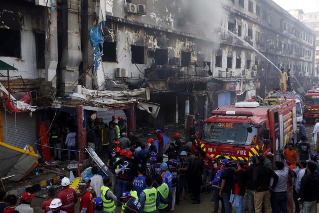 (260120) -- KARACHI, Jan. 20, 2026 (Xinhua) -- Rescuers work at the fire site at a shopping mall in southern Pakistani port city of Karachi on Jan. 20, 2026. The death toll from a massive fire at a multi-storey commercial building in Pakistan's southern port city of Karachi has risen to 26, while 74 people are still missing, officials said on Tuesday. (Str/Xinhua)