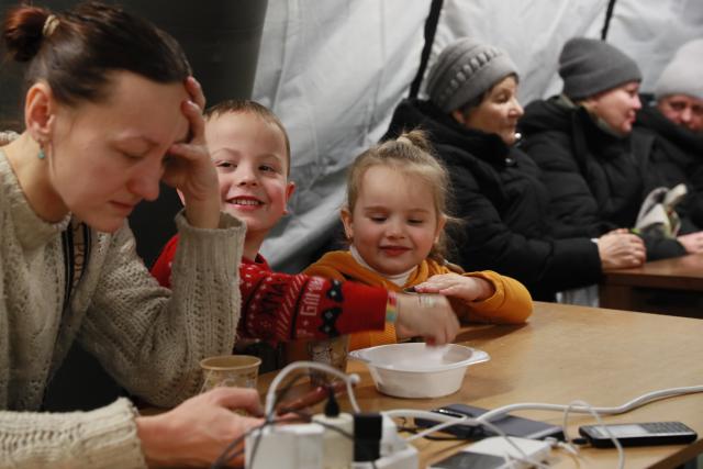 (260121) -- KIEV, Jan. 21, 2026 (Xinhua) -- People stay warm and charge their electronic devices at a temporary shelter in Kiev, Ukraine, Jan. 20, 2026. Russia's air raids caused large-scale power and water supply disruptions in Ukraine's capital of Kiev on Tuesday, said Kiev Mayor Vitali Klitschko.
   A total of 5,635 apartment buildings in Kiev were left without heating following Russia's overnight aerial attacks, Klitschko wrote on social media Telegram. (Xinhua/Li Dongxu)