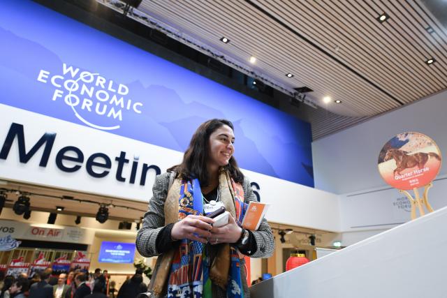 (260121) -- DAVOS, Jan. 21, 2026 (Xinhua) -- A participant looks at a decoration themed on the Chinese lunar Year of the Horse during the "Dalian Night" reception at the World Economic Forum (WEF) Annual Meeting 2026 in Davos, Switzerland, Jan. 20, 2026. Northeast China's coastal city of Dalian held a reception here on Tuesday evening, featuring music performances and local gourmet cuisine. Dalian will host the WEF's Annual Meeting of the New Champions 2026, also known as the Summer Davos, in June. (Xinhua/Lian Yi)