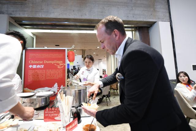 (260121) -- DAVOS, Jan. 21, 2026 (Xinhua) -- A participant tastes Chinese dumplings during the "Dalian Night" reception at the World Economic Forum (WEF) Annual Meeting 2026 in Davos, Switzerland, Jan. 20, 2026. Northeast China's coastal city of Dalian held a reception here on Tuesday evening, featuring music performances and local gourmet cuisine. Dalian will host the WEF's Annual Meeting of the New Champions 2026, also known as the Summer Davos, in June. (Xinhua/Lian Yi)