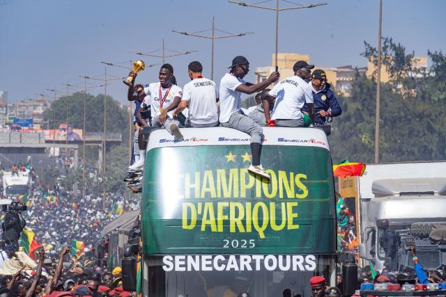 (260121) -- DAKAR, Jan. 21, 2026 (Xinhua) -- Players of the Senegalese football team take an open-top bus and celebrate with thousands of cheering fans during a victory parade in Dakar, Senegal, Jan. 20, 2026. Senegalese football team, "Lions of Teranga", continued their victory parade through the streets of Dakar after winning the Africa Cup of Nations title on Jan. 18 in Rabat, Morocco. (Photo by Aliou Mbaye/Xinhua)