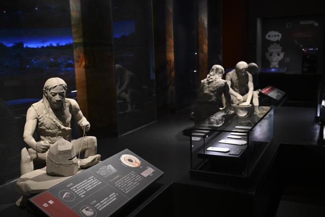 (260121) -- MA'ANSHAN, Jan. 21, 2026 (Xinhua) -- This photo taken on Dec. 24, 2025 shows a reconstructed scene of the ancient people making jade artifacts at the Lingjiatan Site Museum in Hanshan County, Ma'anshan, east China's Anhui Province. Dating back some 5,300 to 5,800 years, the Lingjiatan relic site in east China's Anhui was discovered in 1985. It is known for the jadeware unearthed there. The findings include jade artifacts in various shapes, offering a peek into the spirits and aesthetics of a prehistoric Chinese jade culture. (Xinhua/Huang Bohan)