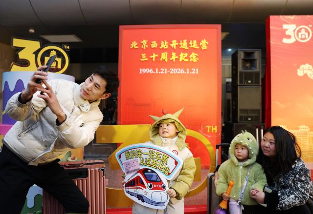 (260121) -- BEIJING, Jan. 21, 2026 (Xinhua) -- Passengers take photos at the Beijing West Railway Station in Beijing, capital of China, on Jan. 21, 2026. The Beijing West Railway Station marked its 30th anniversary on Wednesday. Over the past three decades, this modern transport hub has handled more than 1.96 billion passenger trips, standing as a witness to China's development and the evolution of its railway network. (Xinhua/Zhang Chenlin)