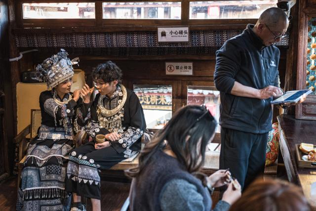 (260121) -- LIJIANG, Jan. 21, 2026 (Xinhua) -- He Dehua (R) sets up music player for customers at the "Wayfarers" music club at the ancient city of Lijiang, southwest China's Yunnan Province, Jan. 16, 2026. He Dehua, 51, and his wife refurbished an old house of theirs in October 2025, and turned it into a music club called "Wayfarers," where they can share their personal stories with travelers and long-lost friends.
   The name "Wayfarers" came from a CD He had co-produced, drawing inspiration from his memory of watching elders of the family leaving hometown to work for livelihood. "We are all wayfarers in our own life, but we must not forget to search for the truth of life and the true self," said He.
   He has been a career musician for about three decades since he went to learn guitar playing in Beijing in 1997. Back to his hometown in Lijiang, he started to challenge himself by impressing the visitors to this olden city with music, songs and sounds of nature.
   He set out to collect voices and sounds in 2011, and has garnered more than 200 hours of recordings, which included some intangible cultural heritage items, voices in routine life, and melodies performed by folk artists. (Xinhua/Wang Guansen)