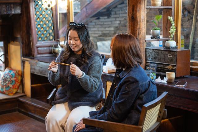 (260121) -- LIJIANG, Jan. 21, 2026 (Xinhua) -- A customer learns about the Chinese mouth harp at the "Wayfarers" music club at the ancient city of Lijiang, southwest China's Yunnan Province, Jan. 16, 2026. He Dehua, 51, and his wife refurbished an old house of theirs in October 2025, and turned it into a music club called "Wayfarers," where they can share their personal stories with travelers and long-lost friends.
   The name "Wayfarers" came from a CD He had co-produced, drawing inspiration from his memory of watching elders of the family leaving hometown to work for livelihood. "We are all wayfarers in our own life, but we must not forget to search for the truth of life and the true self," said He.
   He has been a career musician for about three decades since he went to learn guitar playing in Beijing in 1997. Back to his hometown in Lijiang, he started to challenge himself by impressing the visitors to this olden city with music, songs and sounds of nature.
   He set out to collect voices and sounds in 2011, and has garnered more than 200 hours of recordings, which included some intangible cultural heritage items, voices in routine life, and melodies performed by folk artists. (Xinhua/Gao Yongwei)