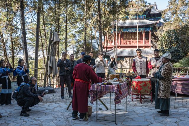 (260121) -- LIJIANG, Jan. 21, 2026 (Xinhua) -- He Dehua (3rd L) collects sounds at a park at the ancient city of Lijiang, southwest China's Yunnan Province, Jan. 16, 2026. He Dehua, 51, and his wife refurbished an old house of theirs in October 2025, and turned it into a music club called "Wayfarers," where they can share their personal stories with travelers and long-lost friends.
   The name "Wayfarers" came from a CD He had co-produced, drawing inspiration from his memory of watching elders of the family leaving hometown to work for livelihood. "We are all wayfarers in our own life, but we must not forget to search for the truth of life and the true self," said He.
   He has been a career musician for about three decades since he went to learn guitar playing in Beijing in 1997. Back to his hometown in Lijiang, he started to challenge himself by impressing the visitors to this olden city with music, songs and sounds of nature.
   He set out to collect voices and sounds in 2011, and has garnered more than 200 hours of recordings, which included some intangible cultural heritage items, voices in routine life, and melodies performed by folk artists. (Xinhua/Wang Guansen)