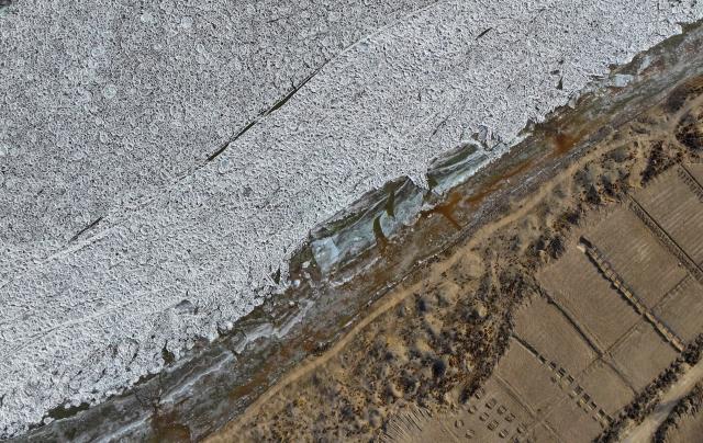 (260121) -- YINCHUAN, Jan. 21, 2026 (Xinhua) -- An aerial drone photo taken on Jan. 21, 2026 shows the frozen surface of the Yellow River along the border of Shizuishan City of northwest China's Ningxia Hui Autonomous Region and Wuhai City of north China's Inner Mongolia Autonomous Region amid a cold wave. (Photo by Yuan Hongyan/Xinhua)
