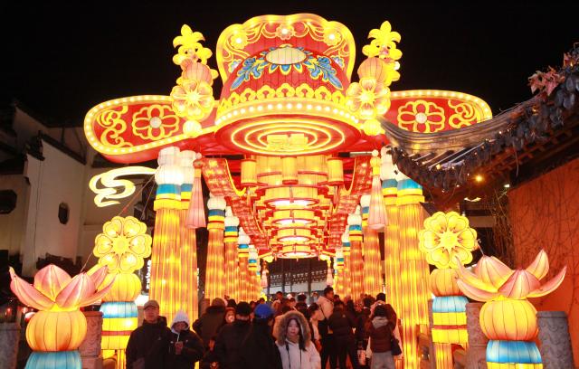 (260121) -- NANJING, Jan. 21, 2026 (Xinhua) -- Tourists view light decorations displayed at the Confucius Temple scenic area during the 40th Qinhuai Lantern Festival in Nanjing, east China's Jiangsu Province, Jan. 21, 2026. The lighting ceremony of the festival was held at the Bailuzhou Park on Wednesday. The festival can be visited in several exhibition areas near the Qinhuai river in the city of Nanjing. (Photo by Liu Jianhua/Xinhua)