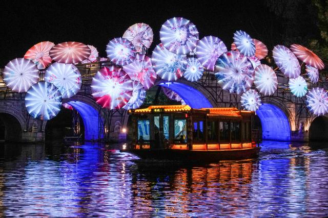 (260121) -- NANJING, Jan. 21, 2026 (Xinhua) -- Tourists take a boat viewing light decorations displayed at the Bailuzhou Park during the 40th Qinhuai Lantern Festival in Nanjing, east China's Jiangsu Province, Jan. 21, 2026. The lighting ceremony of the festival was held at the Bailuzhou Park on Wednesday. The festival can be visited in several exhibition areas near the Qinhuai river in the city of Nanjing. (Xinhua/Li Bo)