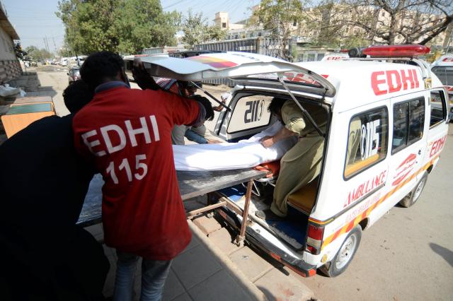 (260121) -- KARACHI, Jan. 21, 2026 (Xinhua) -- Rescuers transfer a body at a mortuary following a fire at a shopping mall in southern Pakistani port city of Karachi on Jan. 21, 2026. The death toll from a shopping mall fire in Pakistan's southern port city of Karachi climbed to 60 after at least 30 bodies were recovered from a shop of the multi-storey building, officials said on Wednesday. (Str/Xinhua)