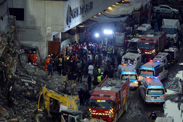 (260121) -- KARACHI, Jan. 21, 2026 (Xinhua) -- Rescuers gather at the fire site of a shopping mall in southern Pakistani port city of Karachi on Jan. 21, 2026. The death toll from a shopping mall fire in Pakistan's southern port city of Karachi climbed to 60 after at least 30 bodies were recovered from a shop of the multi-storey building, officials said on Wednesday. (Str/Xinhua)
