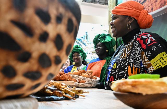 (260122) -- MADRID, Jan. 22, 2026 (Xinhua) -- Staff members offer visitors traditional snack at the exhibition area of Senegal during the 2026 FITUR international tourism exhibition in Madrid, Spain, Jan. 21, 2026. The 2026 FITUR international tourism exhibition opened on Wednesday in Madrid, showcasing the latest development, innovative trends and cooperation opportunities in the tourism industry. 
   This year's fair has attracted over 10,000 companies and nearly 1,000 exhibitors from 161 countries and regions, with 255,000 attendees expected over the five days. (Xinhua/Cheng Min)