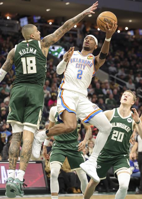 (260122) -- MILWAUKEE, Jan. 22, 2026 (Xinhua) -- Oklahoma City Thunder's Shai Gilgeous-Alexander (top R) drives to the basket during the 2025-2026 NBA regular season game between Milwaukee Bucks and Oklahoma City Thunder in Milwaukee, the United States, Jan. 21, 2026. (Photo by Joel Lerner/Xinhua)