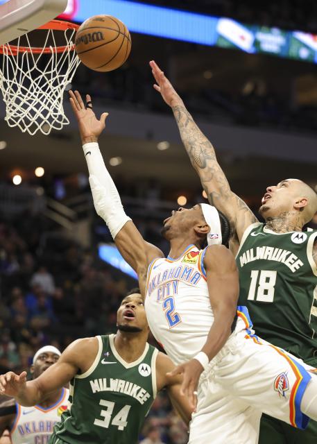 (260122) -- MILWAUKEE, Jan. 22, 2026 (Xinhua) -- Oklahoma City Thunder's Shai Gilgeous-Alexander (2nd R) drives to the basket against Milwaukee Bucks' Kyle Kuzma (1st R) during the 2025-2026 NBA regular season game between Milwaukee Bucks and Oklahoma City Thunder in Milwaukee, the United States, Jan. 21, 2026. (Photo by Joel Lerner/Xinhua)