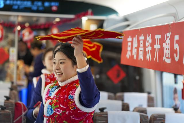(260122) -- HARBIN, Jan. 22, 2026 (Xinhua) -- Train attendants perform on bullet train G902 from Harbin, northeast China's Heilongjiang Province, to Beijing, capital of China, on Jan. 22, 2026. The Beijing-Harbin high-speed railway marked the 5th anniversary of its full operation on Thursday. At 1,198 kilometers, the rail line links China's northeastern provinces of Liaoning, Jilin and Heilongjiang with the capital Beijing. (Xinhua/Wang Song)
