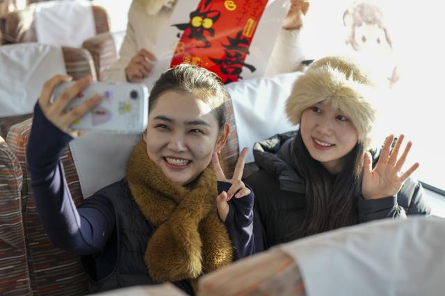 (260122) -- HARBIN, Jan. 22, 2026 (Xinhua) -- Passengers take a selfie on bullet train G902 from Harbin, northeast China's Heilongjiang Province, to Beijing, capital of China, on Jan. 22, 2026. The Beijing-Harbin high-speed railway marked the 5th anniversary of its full operation on Thursday. At 1,198 kilometers, the rail line links China's northeastern provinces of Liaoning, Jilin and Heilongjiang with the capital Beijing. (Xinhua/Wang Song)