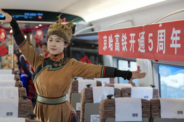 (260122) -- HARBIN, Jan. 22, 2026 (Xinhua) -- A train attendant performs on bullet train G902 from Harbin, northeast China's Heilongjiang Province, to Beijing, capital of China, on Jan. 22, 2026. The Beijing-Harbin high-speed railway marked the 5th anniversary of its full operation on Thursday. At 1,198 kilometers, the rail line links China's northeastern provinces of Liaoning, Jilin and Heilongjiang with the capital Beijing. (Xinhua/Wang Song)