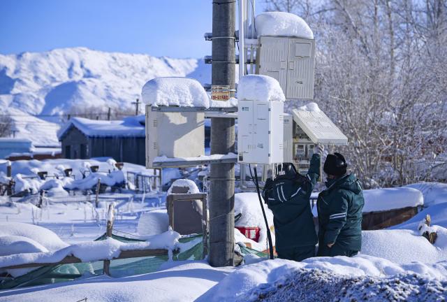 (260122) -- URUMQI, Jan. 22, 2026 (Xinhua) -- Power supply station employees check electricity meters in Turgun Town of Fuyun County in Altay Prefecture, northwest China's Xinjiang Uygur Autonomous Region, on Jan. 16, 2026. A cold wave has swept across the region in recent days, with temperatures in parts of Altay Prefecture dropping to minus 47 degrees Celsius. Amid strong winds and snow, local authorities in charge of transport and energy sectors have coordinated their efforts to ensure uninterrupted heating service and daily supplies for the residents. (Photo by Nurbek Nurman/Xinhua)