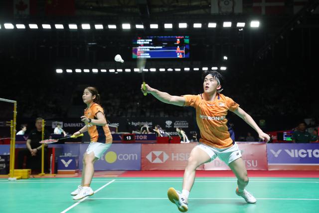 (260122) -- JAKARTA, Jan. 22, 2026 (Xinhua) -- Hoo Pang Ron (R)/Cheng Su Yin of Malaysia compete during the mixed doubles round of 16 match between Guo Xinwa/Chen Fanghui of China and Hoo Pang Ron/Cheng Su Yin of Malaysia at the Indonesia Masters 2026 badminton tournament in Jakarta, Indonesia, Jan. 22, 2026. (Xinhua/Cen Yunpeng)