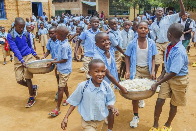 (260122) -- KIGALI, Jan. 22, 2026 (Xinhua) -- Children carry beans and rice dishes to their classroom for lunch at a school in Bugesera District, Eastern Province in Rwanda, on Jan. 20, 2026. Under a children-supporting program launched in 2023, children here are offered meals in schools to address their nutrition problems. (Photo by Cyril Ndegeya/Xinhua)