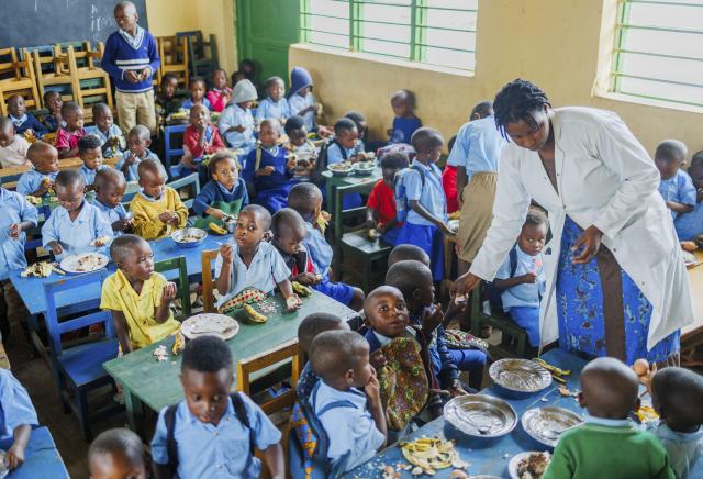 (260122) -- KIGALI, Jan. 22, 2026 (Xinhua) -- A teacher assists children to have their lunch at a classroom of a school in Bugesera District, Eastern Province in Rwanda, on Jan. 20, 2026. Under a children-supporting program launched in 2023, children here are offered meals in schools to address their nutrition problems. (Photo by Cyril Ndegeya/Xinhua)