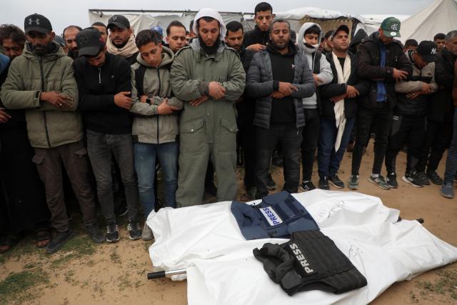 (260122) -- GAZA, Jan. 22, 2026 (Xinhua) -- Mourners pray at the funeral of three Palestinian journalists, who were killed by an Israeli airstrike on Wednesday, in the southern Gaza Strip city of Khan Younis, on Jan. 22, 2026. Eleven Palestinians were killed by Israeli fire on Wednesday across Gaza amid escalating tensions, according to Palestinian sources. (Photo by Rizek Abdeljawad/Xinhua)