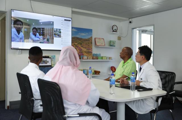 (260122) -- JOHANNESBURG, Jan. 22, 2026 (Xinhua) -- Experts from the Chengdu Second People's Hospital in China participate remotely in an online consultation for patient Jabulane Ngwenwa (2nd R) at the African Center for Traditional Chinese Medicine and Acupuncture in Johannesburg, South Africa, Jan. 21, 2026. TO GO WITH "Feature: Blending tradition, technology: AI-powered TCM brings new hope to South African patients" (Xinhua/Chen Wei)