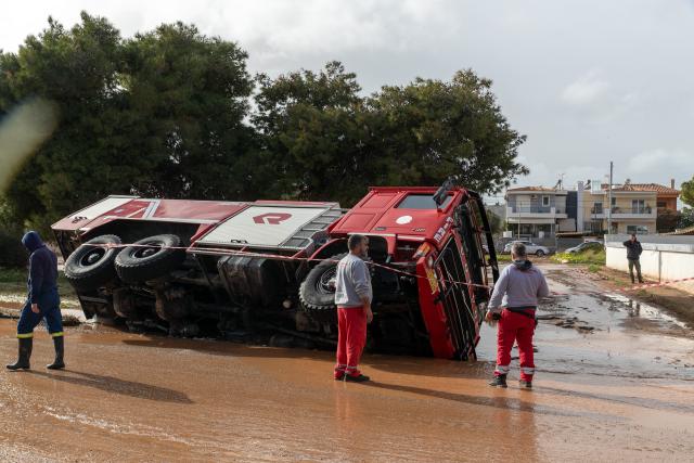 (260123) -- VARI, Jan. 23, 2026 (Xinhua) -- A fire truck is stranded in a road cave-in caused by flooding in Vari, southern Athens, Greece, Jan. 21, 2026. Two people were killed on Wednesday as a severe weather system swept across Greece, authorities said. (Xinhua/Marios Lolos)