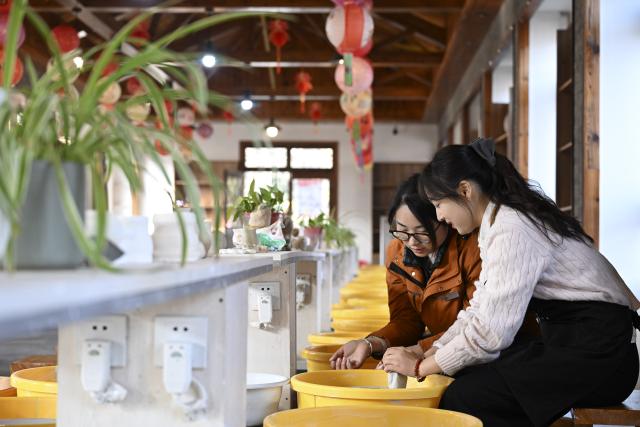 (260123) -- MA'ANSHAN, Jan. 23, 2026 (Xinhua) -- A tourist makes pottery with guidance from a staff member at the Lingjiatan National Archaeological Site Park in Hanshan County, Ma'anshan, east China's Anhui Province, on Dec. 25, 2025. The Lingjiatan relics site in east China's Anhui is a Neolithic settlement dating back 5,300 to 5,800 years, with an area of about 1.6 million square meters. 
  In recent years, the local government has explored ways to combine relic preservation with cultural tourism. In 2023, the Lingjiatan National Archaeological Site Park was officially inaugurated. In 2025, the Lingjiatan Site Museum opened to the public, and has welcomed nearly 200,000 visitors to date. 
  Lingjiatan-themed cultural and creative products as well as immersive experiences have been developed to help promote the relics site among the public. (Xinhua/Huang Bohan)