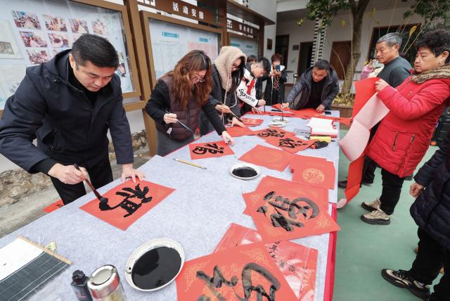 (260123) -- ZHUJI, Jan. 23, 2026 (Xinhua) -- Calligraphy enthusiasts write the Chinese character "Fu" (Fortune) and Spring Festival couplets at a farmers' fair held to welcome the Chinese Lunar New Year in Dongbaihu Town of Zhuji, east China's Zhejiang Province, Jan. 23, 2026. (Xinhua/Xu Yu)