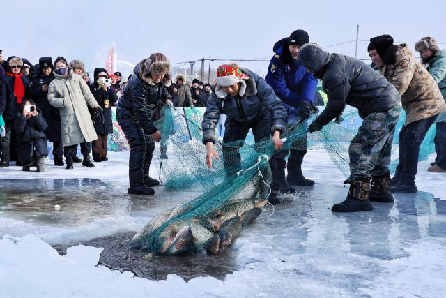 (260123) -- TONGJIANG, Jan. 23, 2026 (Xinhua) -- This photo taken on Jan. 23, 2026 shows a scene of a winter fishing festival in Jiejinkou Hezhe Ethnic Township, Tongjiang City, northeast China's Heilongjiang Province. The event, held on a frozen lake, is part of the province's winter fishing events. It integrates traditional Hezhe fishing and hunting culture with folk sports, offering visitors an immersive experience of the icy landscape and unique Hezhe customs. (Photo by Liu Wanping/Xinhua)
