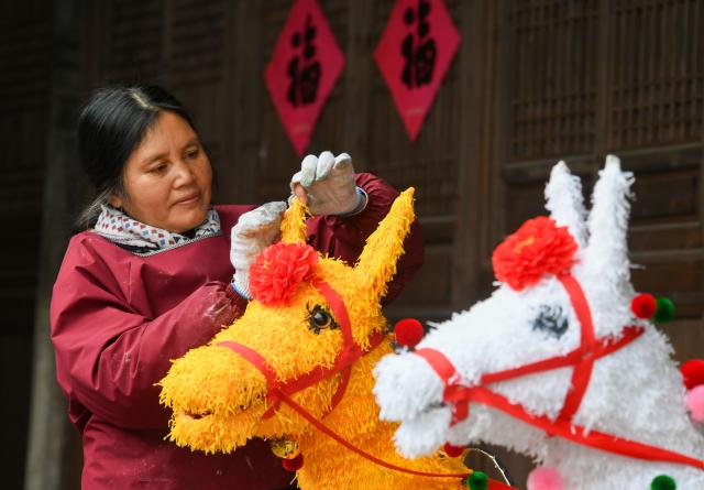 (260123) -- BEIJING, Jan. 23, 2026 (Xinhua) -- A villager makes traditional revolving horse lanterns at an ancient house in Zhoujia Village, Pujiang County of Jinhua City, east China's Zhejiang Province, Jan. 21, 2026. Chinese people are busy preparing fresh flowers, Chinese knots, spring couplets, and other traditional necessities to celebrate the upcoming Spring Festival, or the Chinese New Year. (Photo by Shi Kuanbing/Xinhua)
