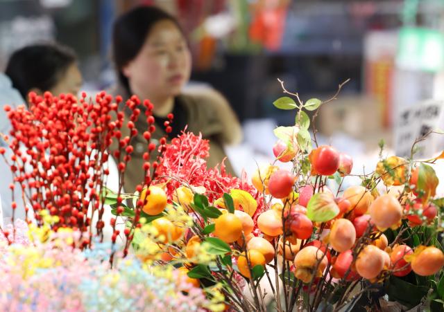 (260123) -- BEIJING, Jan. 23, 2026 (Xinhua) -- People visit a floral market in Jianghan District of Wuhan City, central China's Hubei Province, Jan. 23, 2026. Chinese people are busy preparing fresh flowers, Chinese knots, spring couplets, and other traditional necessities to celebrate the upcoming Spring Festival, or the Chinese New Year. (Photo by Zhao Jun/Xinhua)