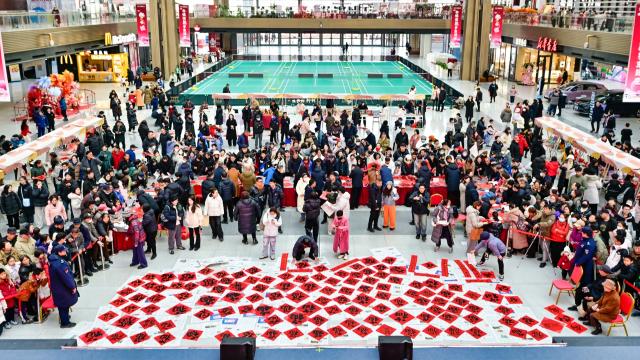 (260123) -- BEIJING, Jan. 23, 2026 (Xinhua) -- Artists write spring couplets and Chinese character "Fu," which means good fortunes, for citizens at a cultural center in Tianjin, north China, Jan. 22, 2026. Chinese people are busy preparing fresh flowers, Chinese knots, spring couplets, and other traditional necessities to celebrate the upcoming Spring Festival, or the Chinese New Year. (Photo by Du Penghui/Xinhua)