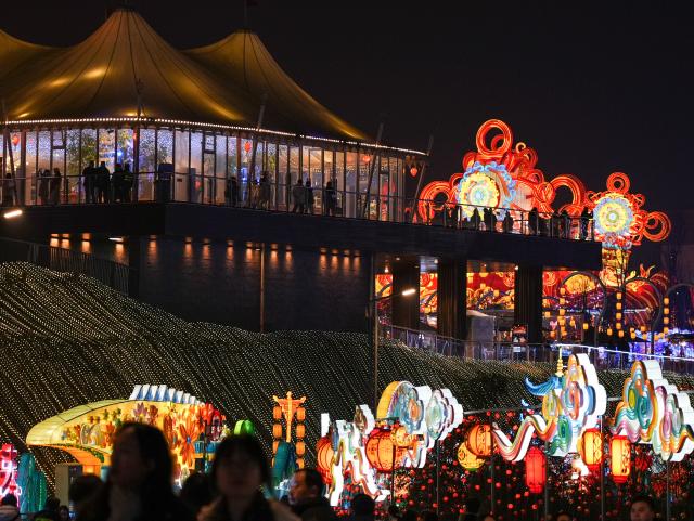 (260123) -- ZIGONG, Jan. 23, 2026 (Xinhua) -- Tourists visit the 32nd Zigong International Dinosaur Lantern Show in Zigong, southwest China's Sichuan Province, Jan. 23, 2026. All lanterns displayed at the show were lit up on Friday evening. This year's show features 11  groups of large light sets and more than 200 groups of small and medium-sized light sets. (Xinhua/Wang Xi)