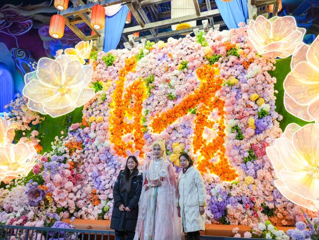 (260123) -- ZIGONG, Jan. 23, 2026 (Xinhua) -- Tourists visit the 32nd Zigong International Dinosaur Lantern Show in Zigong, southwest China's Sichuan Province, Jan. 23, 2026. All lanterns displayed at the show were lit up on Friday evening. This year's show features 11  groups of large light sets and more than 200 groups of small and medium-sized light sets. (Xinhua/Wang Xi)