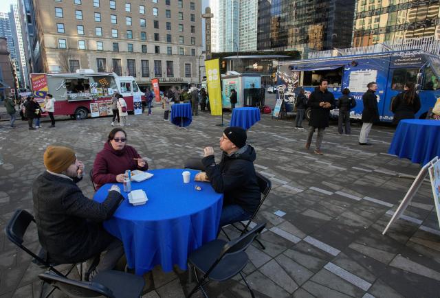 (260124) -- VANCOUVER, Jan. 24, 2026 (Xinhua) -- People enjoy their food ordered from food trucks during the "Street Food City" event in Vancouver, British Columbia, Canada, Jan. 23, 2026. (Photo by Liang Sen/Xinhua)