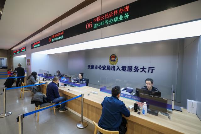 (260124) -- TIANJIN, Jan. 24, 2026 (Xinhua) -- Police officers process citizens' applications at the exit-entry services hall of Tianjin Municipal Public Security Bureau in north China's Tianjin Municipality, Jan. 24, 2026. The exit-entry administration division of Tianjin Municipal Public Security Bureau on Saturday launched a campaign to facilitate the processing of travel documents during the peak travel season around the Spring Festival holiday. Citizens can expect shorter waiting times as more service counters are opened and service hours are extended. (Xinhua/Sun Fanyue)
