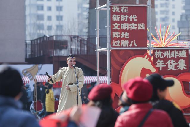 (260124) -- HANGZHOU, Jan. 24, 2026 (Xinhua) -- A folk artist performs "Xiao Re Hun", a traditional form of stand-up comedy in Hangzhou dialect, during a fair featuring intangible cultural heritage and Chinese New Year goods in Hangzhou, east China's Zhejiang Province, on Jan. 24, 2026. Kicking off in Hangzhou on Saturday, the event blends traditional festivities with modern trends, offering visitors an immersive experience of cultural crafts, holiday shopping, and folk performances. (Xinhua/Xu Yu)