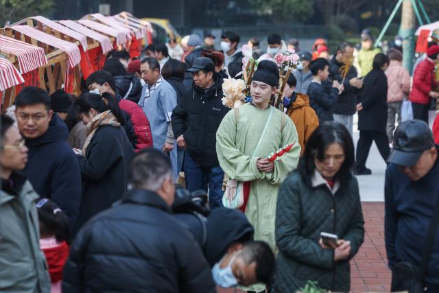 (260124) -- HANGZHOU, Jan. 24, 2026 (Xinhua) -- People are pictured during a fair featuring intangible cultural heritage and Chinese New Year goods in Hangzhou, east China's Zhejiang Province, on Jan. 24, 2026. Kicking off in Hangzhou on Saturday, the event blends traditional festivities with modern trends, offering visitors an immersive experience of cultural crafts, holiday shopping, and folk performances. (Xinhua/Xu Yu)