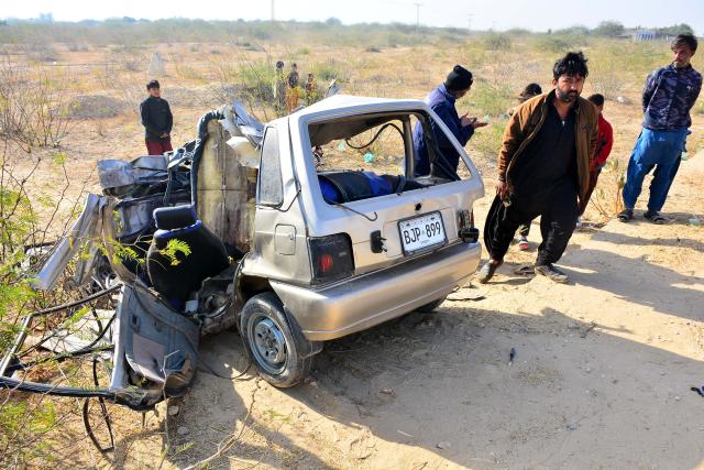 (260124) -- JAMSHORO, Jan. 24, 2026 (Xinhua) -- Locals gather near a damaged car at the accident site in Jamshoro district in Sindh province, Pakistan, on Jan. 24, 2026. A collision between a car and a truck left at least nine people killed and several others injured in Pakistan's southern Sindh province, police said on Saturday. (Str/Xinhua)