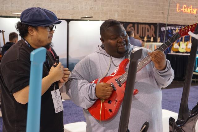 (260124) -- ANAHEIM, Jan. 24, 2026 (Xinhua) -- A visitor plays an electric guitar at the booth of Enya Music during the 2026 National Association of Music Merchants Show at the Anaheim Convention Center in Southern California, the United States, Jan. 22, 2026. TO GO WITH "Roundup: Chinese innovation stands out at leading North American music industry show" (Photo by Zeng Hui/Xinhua)