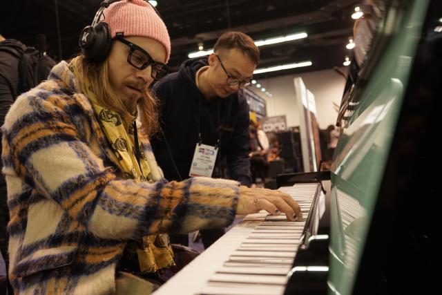 (260124) -- ANAHEIM, Jan. 24, 2026 (Xinhua) -- A visitor plays a piano at the booth of Pearl River Piano during the 2026 National Association of Music Merchants Show at the Anaheim Convention Center in Southern California, the United States, Jan. 22, 2026. TO GO WITH "Roundup: Chinese innovation stands out at leading North American music industry show" (Photo by Zeng Hui/Xinhua)