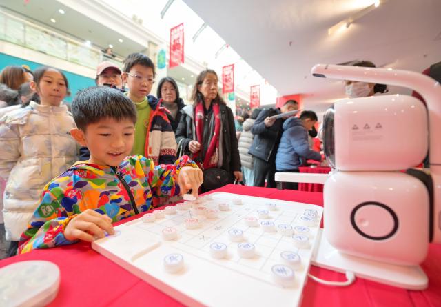 (260124) -- TIANJIN, Jan. 24, 2026 (Xinhua) -- A child plays Xiangqi, a traditional Chinese board game also known as the Chinese chess, during a temple fair for children in north China's Tianjin, on Jan. 24, 2026. A special temple fair tailored for children kicked off in north China's Tianjin on Saturday. Crowds of parents and kids gathered at the fair to experience the festive atmosphere ahead of the Spring Festival. The event features a variety of activities including traditional handicraft making, Tianjin-style food tasting, and interactive games. (Xinhua/Zhao Zishuo)