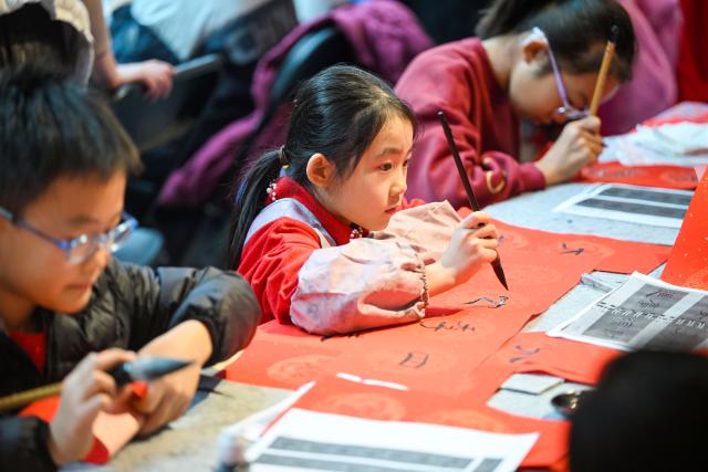(260124) -- TIANJIN, Jan. 24, 2026 (Xinhua) -- Children write Spring Festival couplets during a temple fair for children in north China's Tianjin, on Jan. 24, 2026. A special temple fair tailored for children kicked off in north China's Tianjin on Saturday. Crowds of parents and kids gathered at the fair to experience the festive atmosphere ahead of the Spring Festival. The event features a variety of activities including traditional handicraft making, Tianjin-style food tasting, and interactive games. (Xinhua/Zhao Zishuo)